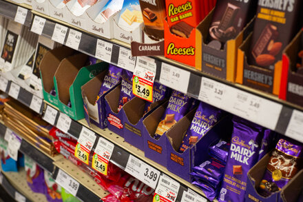 A close-up of a well-known Canadian chocolate bar, now discontinued, with a blurred background suggesting a grocery store aisle or a home setting.