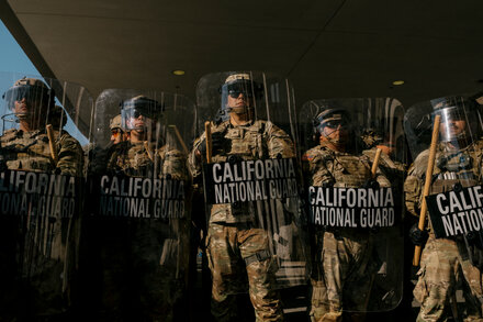 Heavily armed National Guard troops stand guard outside a retail store in Los Angeles during protests.