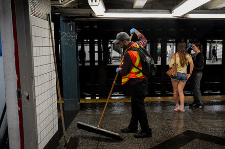 A submerged subway station entrance in New York City, with floodwaters reaching several feet high, reflecting the impact of severe storms.
