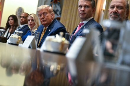 Donald Trump with members of his cabinet, showing a mix of individuals and a general impression of a diverse group in a professional setting, possibly a meeting or a press conference.