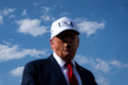 Donald Trump with a 'reverse' button, symbolizing policy changes.