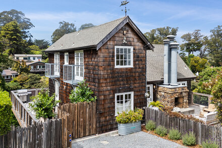 Exterior of a modern, multi-story home with large windows and decks overlooking a scenic coastal landscape in Bolinas, California, priced at $4 million.