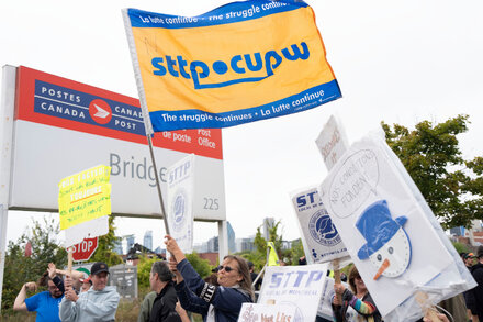 Canada Post mail carrier delivering letters, symbolizing the potential labor showdown