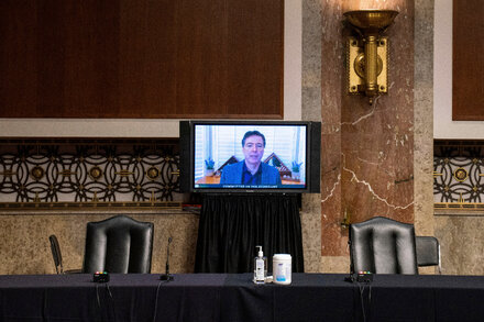James Comey testifying before a congressional committee, with intense focus on the process.