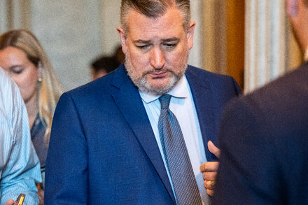 Senator Ted Cruz speaks at a podium. He gestures with his hand as he makes a point.