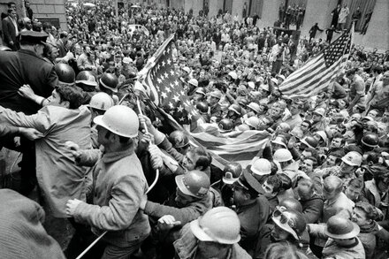 A group of blue-collar workers, perhaps from a factory or construction site, looking on with thoughtful or concerned expressions. The scene should subtly suggest a shift in political alignment, perhaps with faded or symbolic red, white, and blue elements. A diverse group of people, reflecting various demographics within the working class.