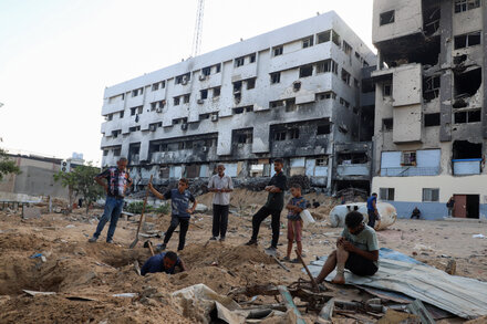Destroyed building in Gaza City, with rubble and debris visible, surrounded by damaged infrastructure, illustrating the impact of intensified Israeli offensive.