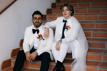 A man in traditional Jewish attire with a humorous, gender-bending twist, possibly wearing an accessory or makeup that challenges gender norms.