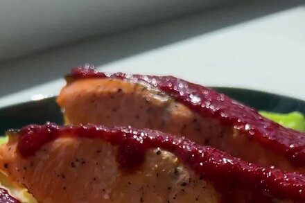 A close-up shot of gochugaru salmon with crispy rice, garnished with fresh herbs, ready to be served.