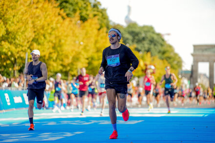 Harry Styles running a marathon in Tracksmith shorts, looking energetic and determined