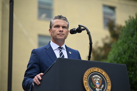 Un grupo de altos mandos militares de Estados Unidos con uniformes de combate y de servicio, escuchando atentamente a un orador no visible, en un evento formal. El ambiente es serio y profesional, con una decoración sobria que sugiere una sala de conferencias o un auditorio.