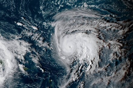 Satellite map showing Hurricane Humberto intensifying rapidly to a Category 3 hurricane over the ocean, with its eye clearly visible.