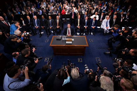 Un retrato de James Comey, exdirector del FBI, mirando fijamente a la cámara, con un fondo neutro.