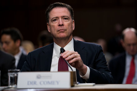 Close-up of James Comey speaking, with a serious expression, at a podium.
