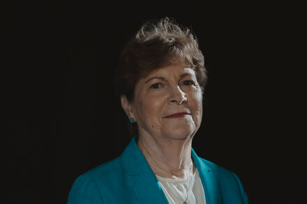 Senator Jeanne Shaheen speaks at a podium, with an American flag visible in the background.