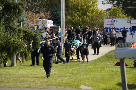 Distraught witness in front of a church engulfed in flames with emergency vehicles present.