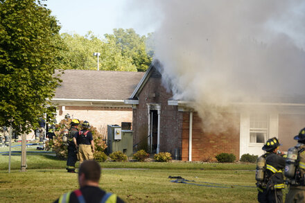 Police cars and emergency vehicles surround a church building with yellow crime scene tape visible.