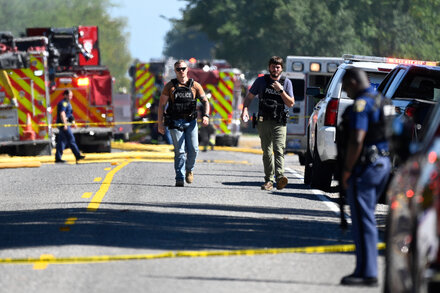 Emergency vehicles, police, and people gathered outside a Mormon church after a shooting incident.