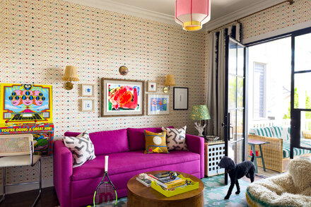 A family in Nashville poses in their living room, which is decorated with unique patterned wallpaper.