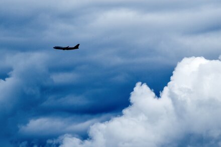 Un avión de pasajeros atravesando nubes oscuras y turbulentas, con relámpagos en el fondo, ilustrando las nuevas teorías sobre las turbulencias aéreas.