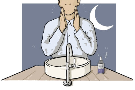 Close-up of a person applying a retinol-based cream or serum to their face, with a focus on smooth, healthy-looking skin.