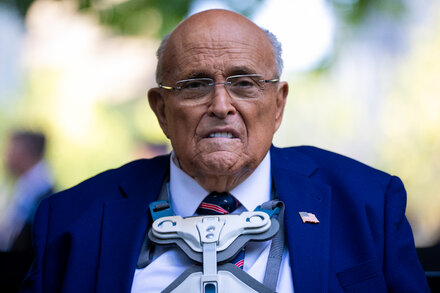 Rudy Giuliani walks out of court with his legal team, looking serious, as part of the Dominion Voting Systems defamation lawsuit.