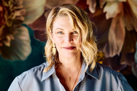 A woman with a thoughtful expression, possibly Jennie Allen or a similar author, in a candid or interview setting, representing a spiritual journey or a shift in belief.