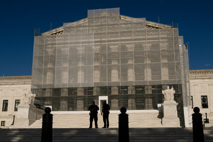 Supreme Court building with an American flag flying, symbolizing the legal challenge to birthright citizenship