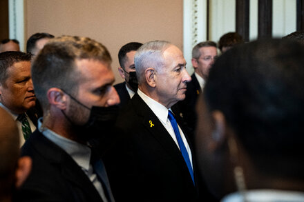 Donald Trump and Benjamin Netanyahu, both smiling, shake hands in an official setting.