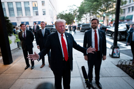 Donald Trump speaking at a rally, with a crowd in the background, representing his stance on free speech.