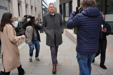 A British politician looking somber, possibly in court or a press conference, with a blurred background suggesting a serious setting. The image should convey the gravity of the politician admitting to pro-Russia statements for bribes.
