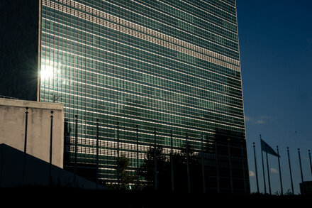 A visual representation of the tension between the United Nations and Donald Trump regarding visa policies, possibly with flags, silhouettes, or a diplomatic setting.