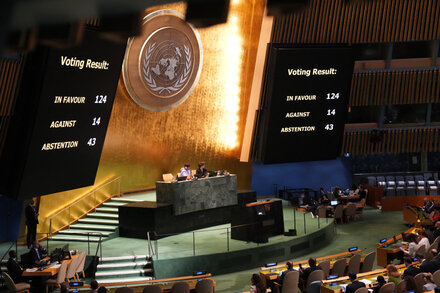 Palestinian President Mahmoud Abbas speaking at a podium with the United Nations emblem behind him, addressing the General Assembly.