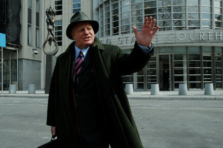 Bruce Cutler, a lawyer known for defending mob boss John Gotti, stands in court, wearing a suit and tie, looking sternly. The background shows a courtroom setting.