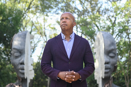 Civil rights lawyer Bryan Stevenson sits in a thoughtful pose, looking directly at the camera, with a blurred background.
