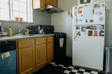 A modern, stainless steel refrigerator stands in an empty kitchen space, ready for use.