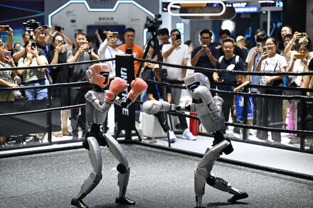 A large exhibition hall in China showcasing various high-tech gadgets and large screens, with a few people walking through, symbolizing China's technological ambition.
