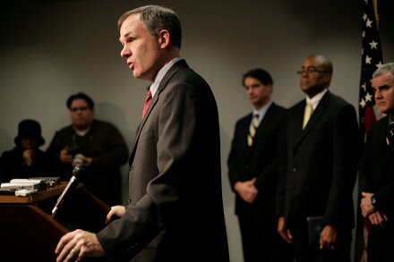 A lawyer, likely Comey's defense counsel, stands in a courtroom or legal setting, looking composed and professional. The image suggests a connection to high-stakes legal proceedings.