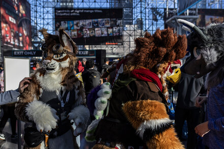 Attendees dressed in elaborate, creative costumes at Comic Con, some with visible references to superhero or fantasy characters, others more abstract.
