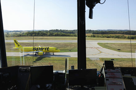 An airplane from a discount airline prepares for takeoff at an airport, with the terminal visible in the background, symbolizing the challenges faced by low-cost carriers.