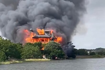 Flames engulfing the roof and windows of a South Carolina state judge's house at night, with smoke rising into the sky.
