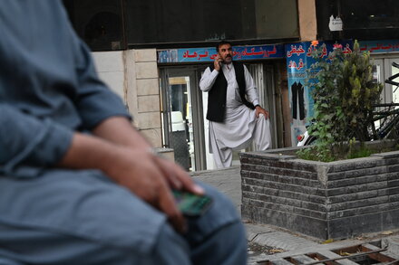 An Afghan man uses a laptop in a partially restored internet cafe in Kabul, symbolizing the return of internet connectivity to Afghanistan after a recent outage.