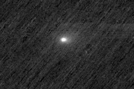 An artist's impression shows a comet with a glowing tail streaking past the red planet Mars, as a spacecraft orbits above.