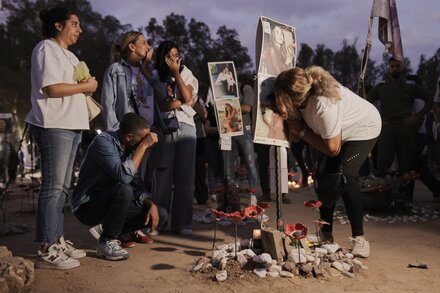 A woman holds a photo of a victim at a memorial event for the Oct. 7 Nova festival attack in Israel.