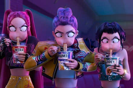 Child reaching for a steaming cup of instant noodles with Kpop Demon Hunters branding, next to a parent looking concerned.