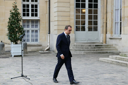 Emmanuel Macron stands with new French cabinet members in a group photo outside Élysée Palace