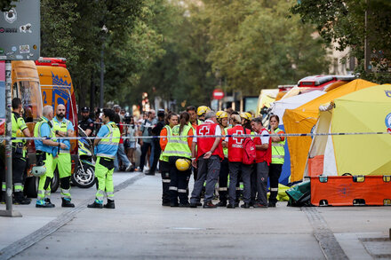 Rescue workers search through rubble at a collapsed hotel construction site in Madrid, with debris and exposed rebar visible.