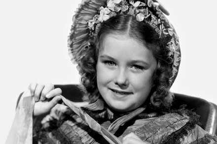 Marilyn Knowlden, a child actress in 1930s Hollywood, pictured in a black and white close-up. She has a shy smile, looking slightly off-camera. She is wearing a light-colored, possibly lace-trimmed, dress.