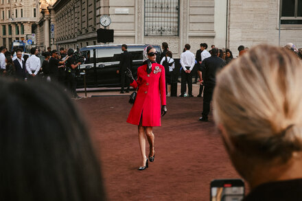 Street style shot of a well-dressed person in Milan, Italy, known for its fashion. They are wearing a stylish outfit with designer elements, walking confidently on a city street.