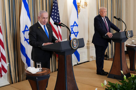 Benjamin Netanyahu and Donald Trump shake hands with serious expressions, symbolizing the diplomatic challenges of the peace process.